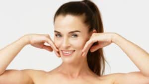 A woman touching her cheeks after RF microneedling in Eureka, CA